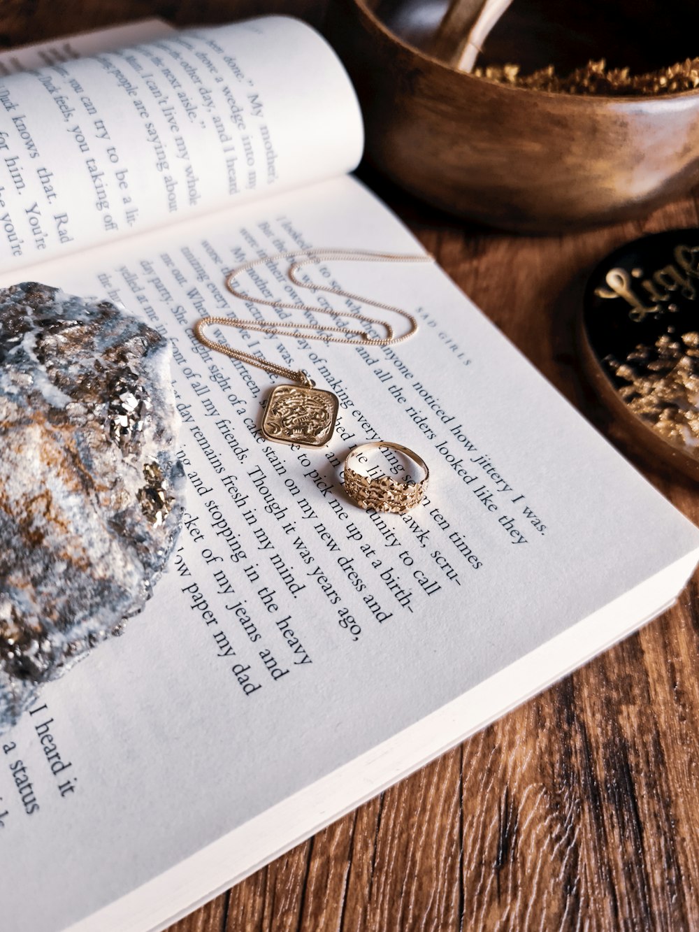 a close up of a book with a pair of earrings on it