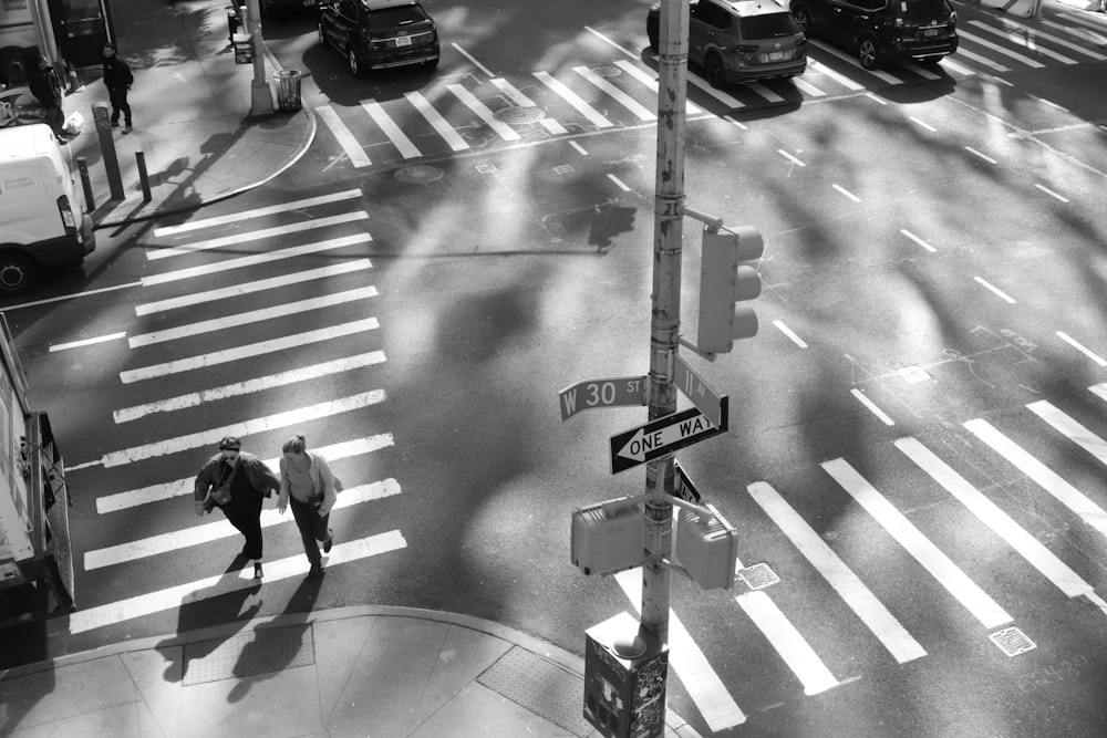 a couple of people walking across a street