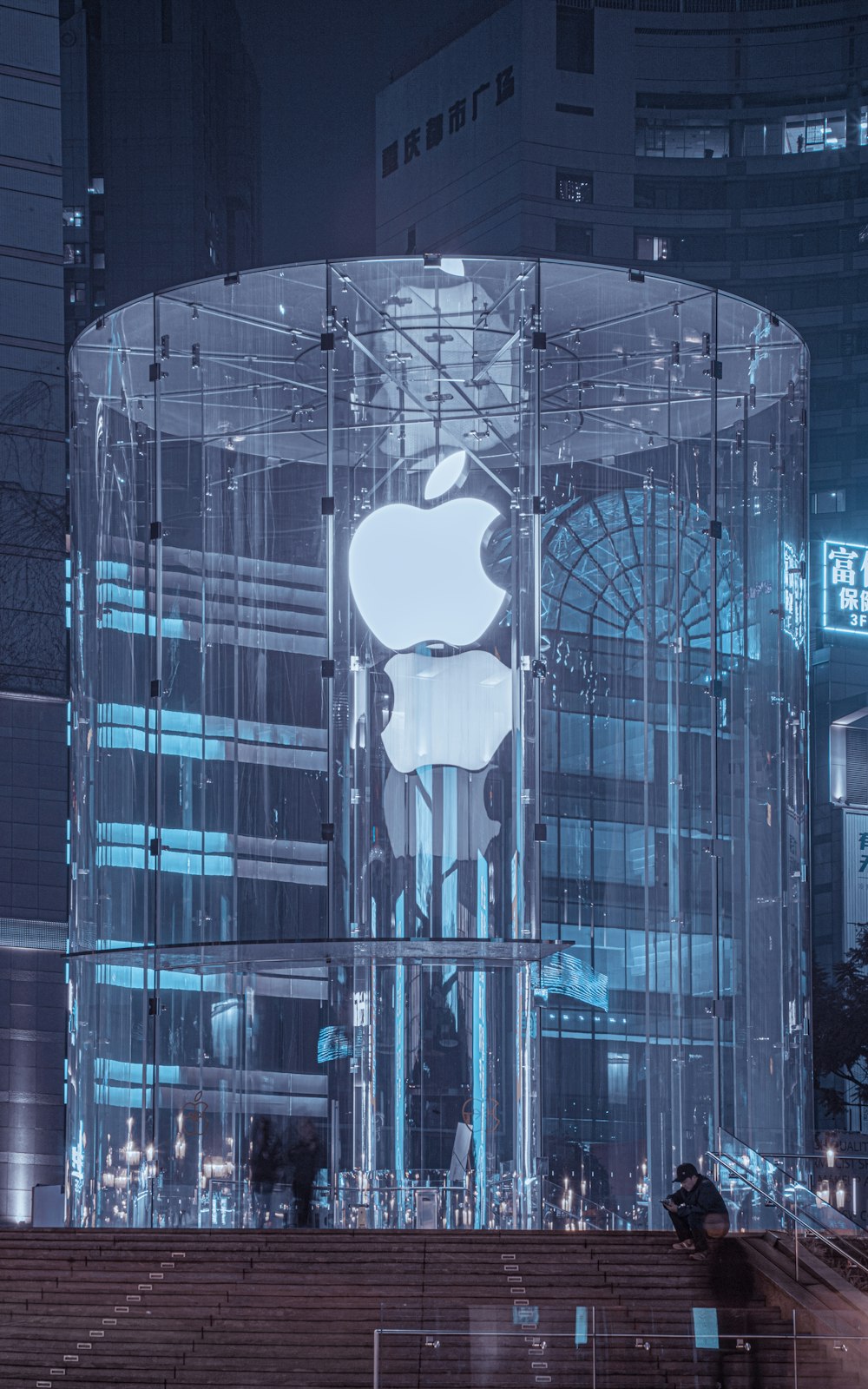 an apple store in the middle of a city at night