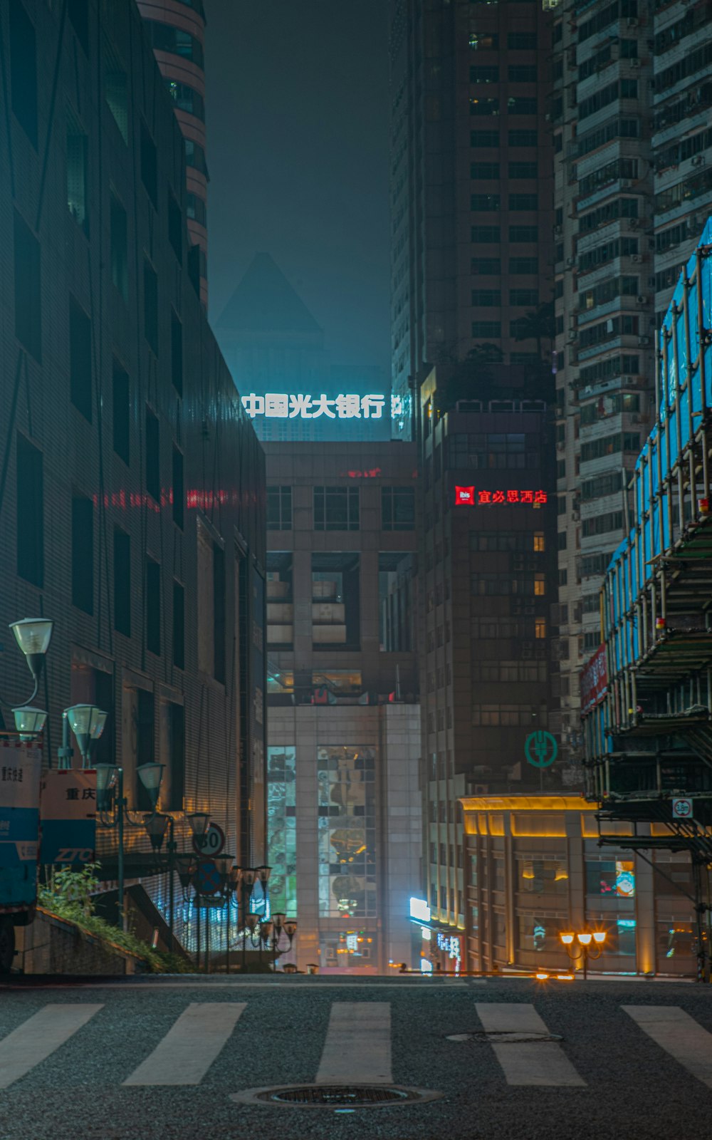 a city street at night with tall buildings