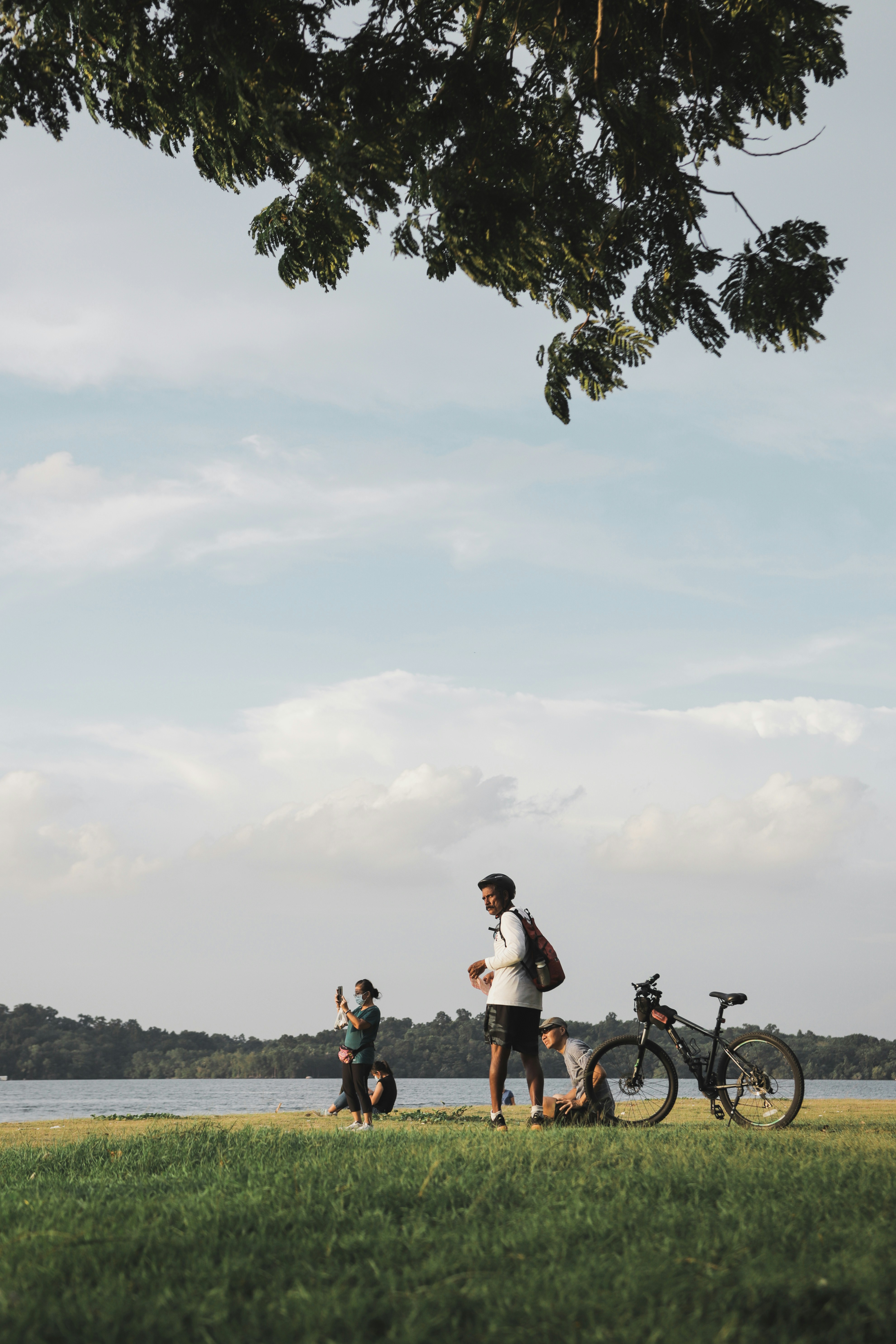a man standing next to a bike on a lush green field