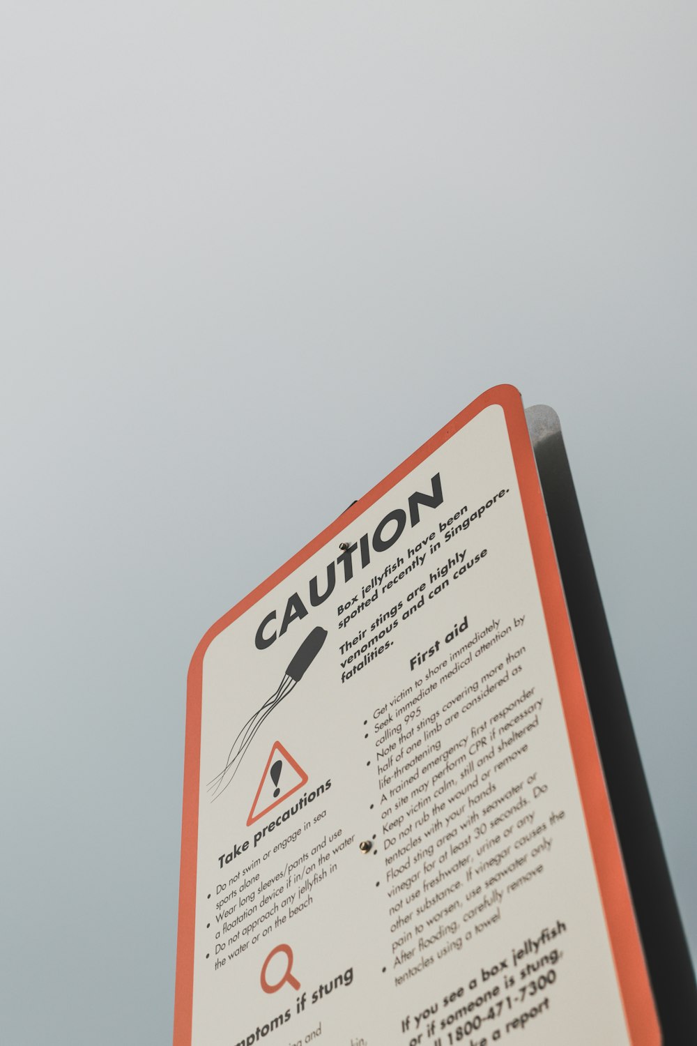 a close up of a caution sign with a sky background