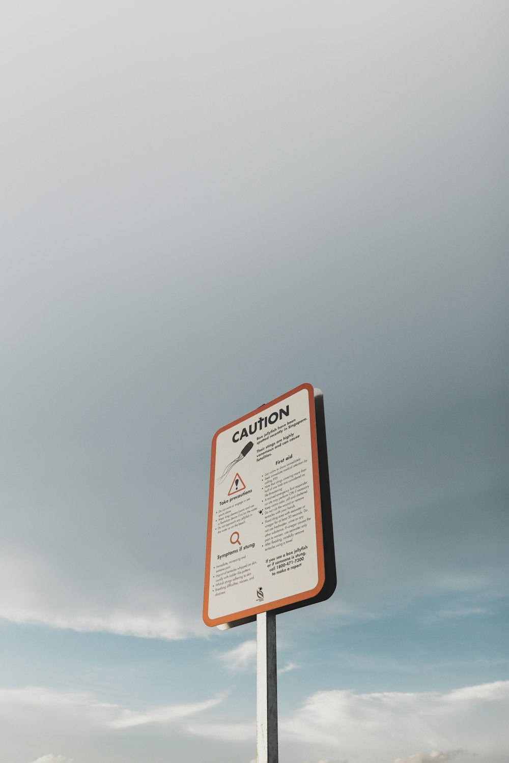 ein Schild, das sich auf einer Stange im Gras befindet