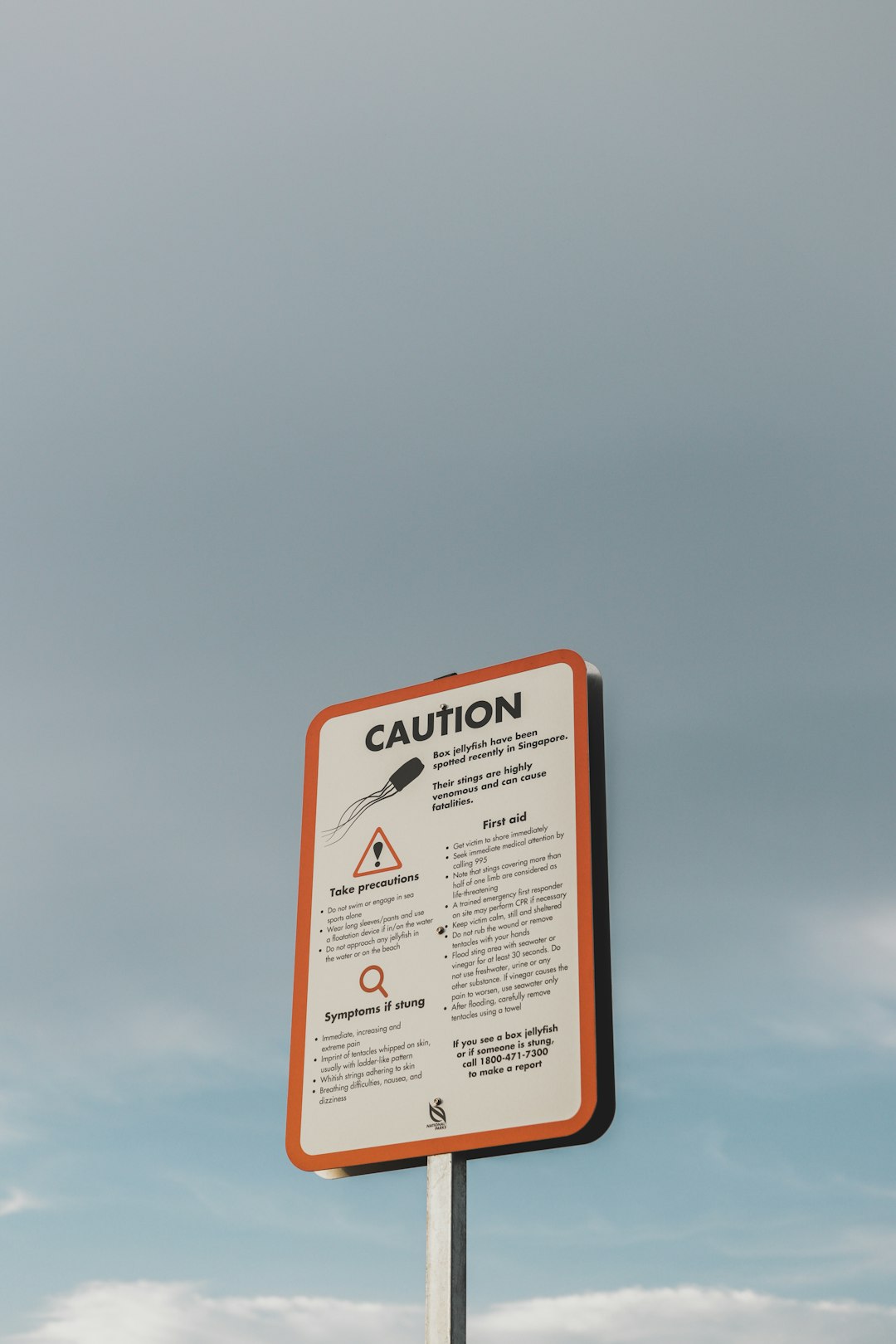 ice plant jade, symptoms, a caution sign on a pole in front of a cloudy sky