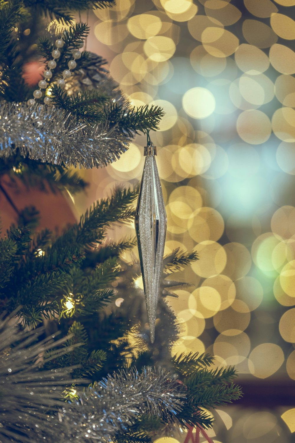 a close up of a christmas tree with lights in the background