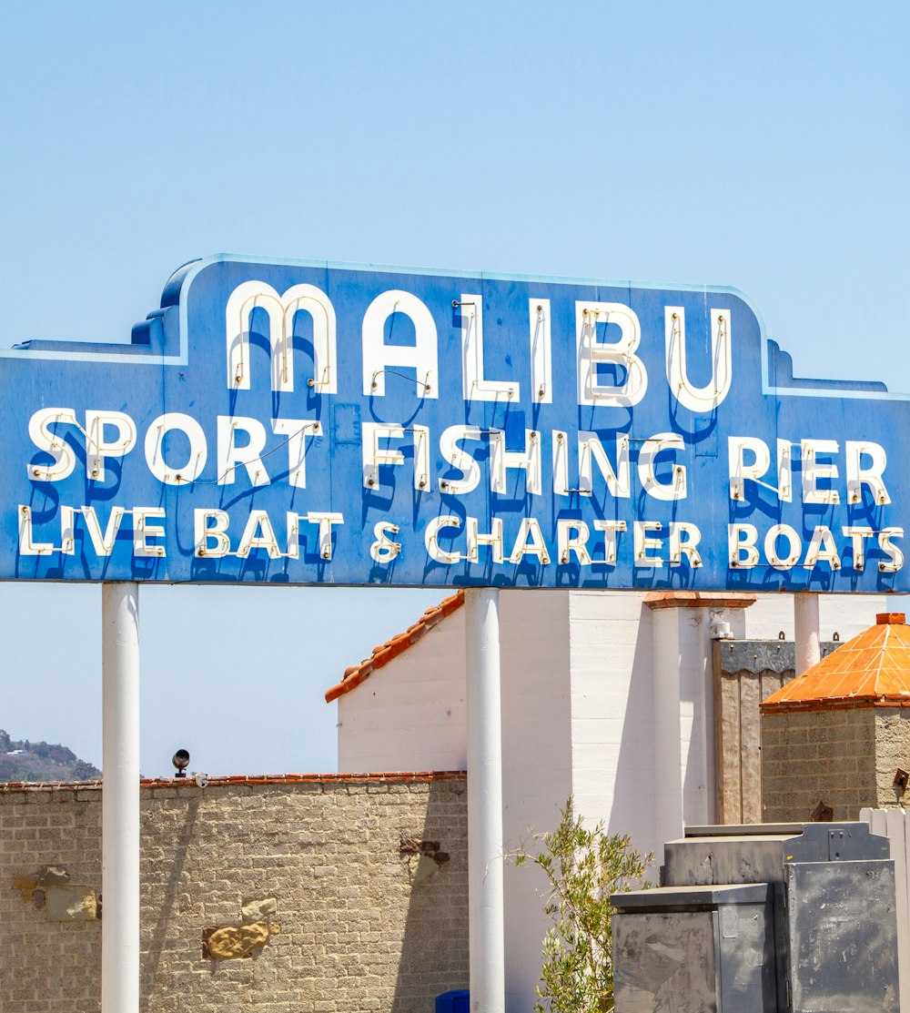 a blue sign that says malibu sport fishing pier