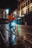 Evening shot of a Lumina windbreaker catching the light as the wearer cycles through bustling streets.