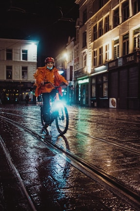 Evening shot of a Lumina windbreaker catching the light as the wearer cycles through bustling streets.