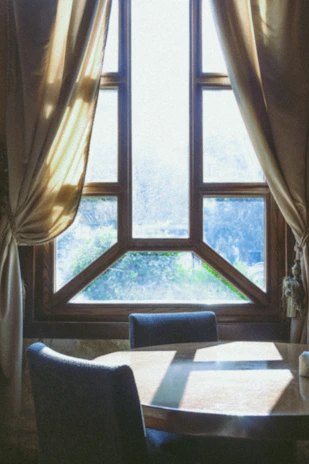 A cozy wooden chair and table set in a sunlit room showcasing handcrafted furniture.