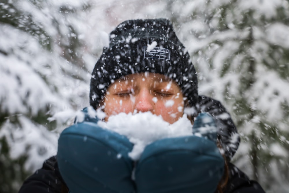 a woman blowing snow in front of her face