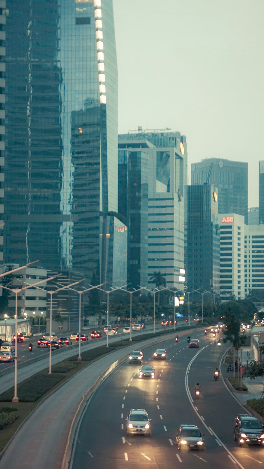 a city street filled with lots of traffic next to tall buildings