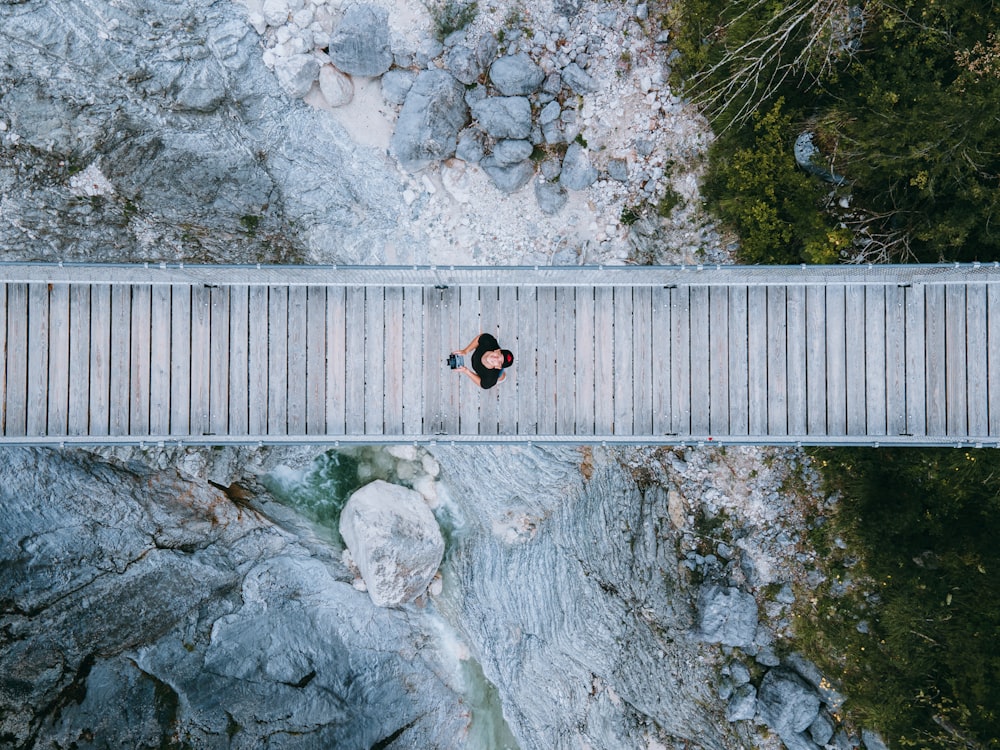 uma pessoa de pé em uma ponte sobre um rio