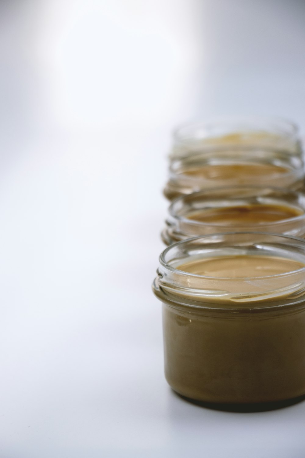 four jars of peanut butter sitting on a table