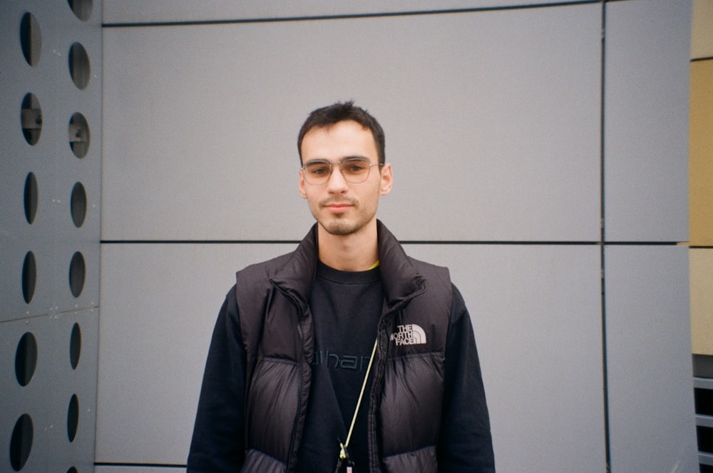 a man standing in front of a gray wall