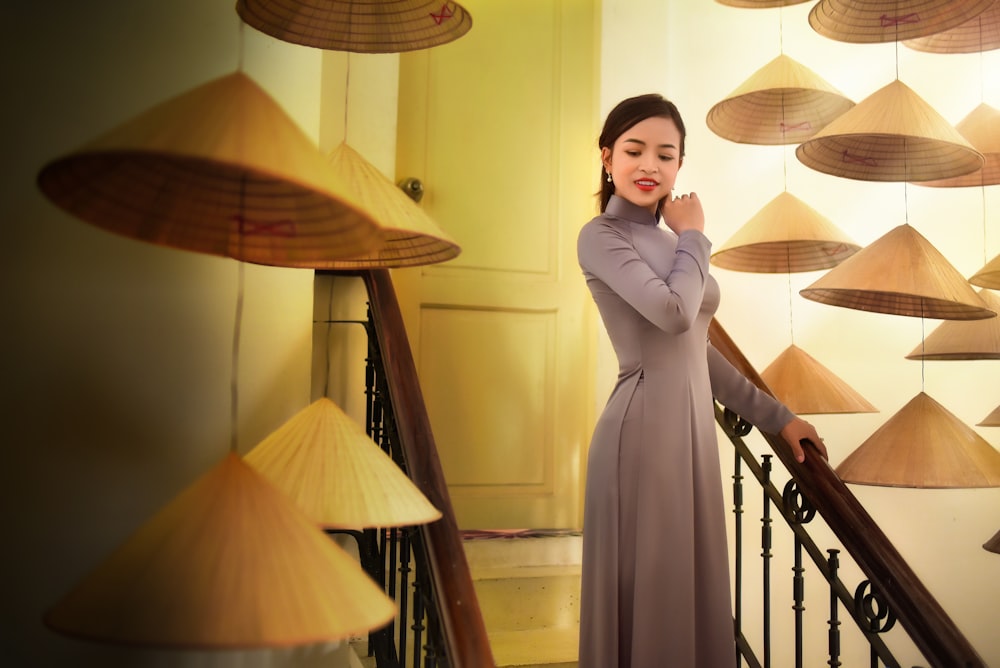 a woman in a long dress standing on a stair