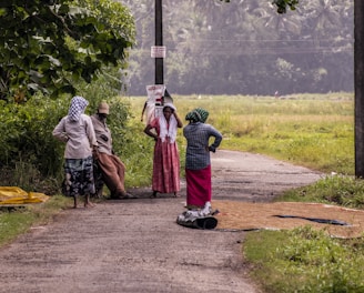 a group of people standing on a dirt road