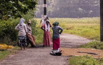 a group of people standing on a dirt road