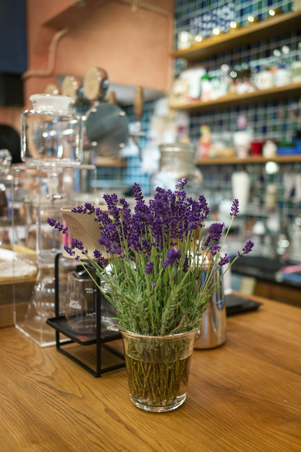 a vase filled with purple flowers sitting on top of a wooden table