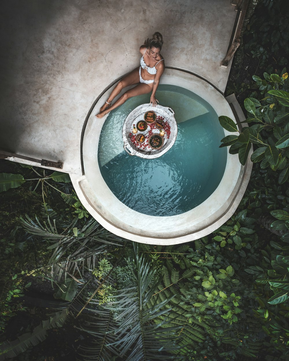 a woman in a white bikini sitting on a white toilet