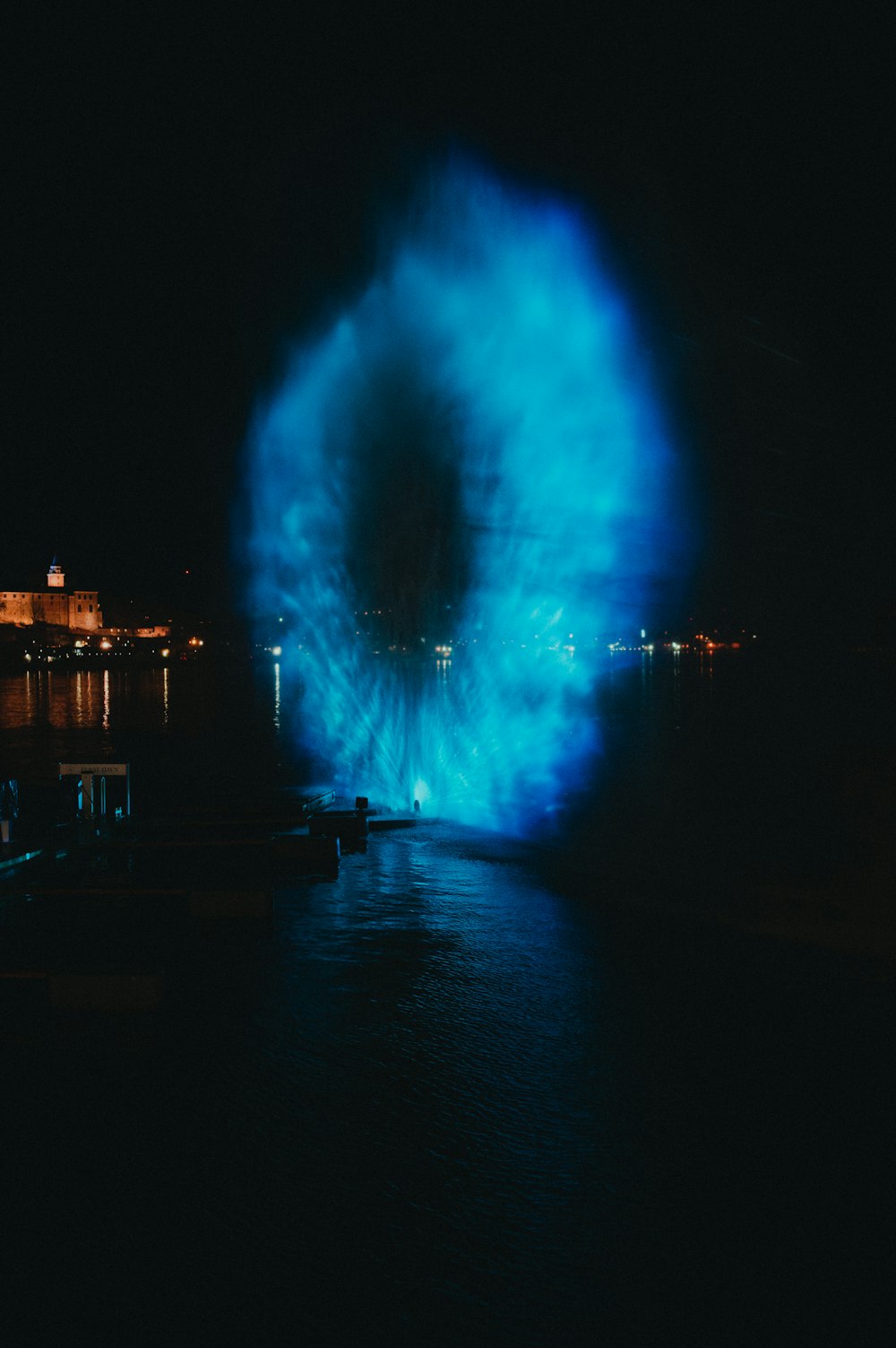 a large blue firework in the middle of a body of water