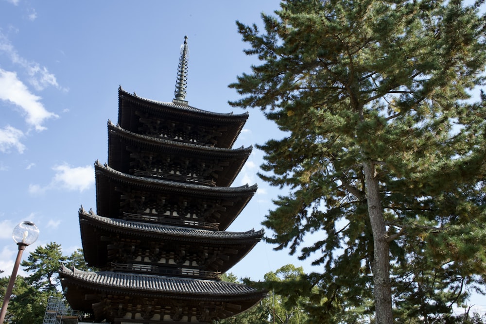 a tall pagoda tower sitting next to a tree