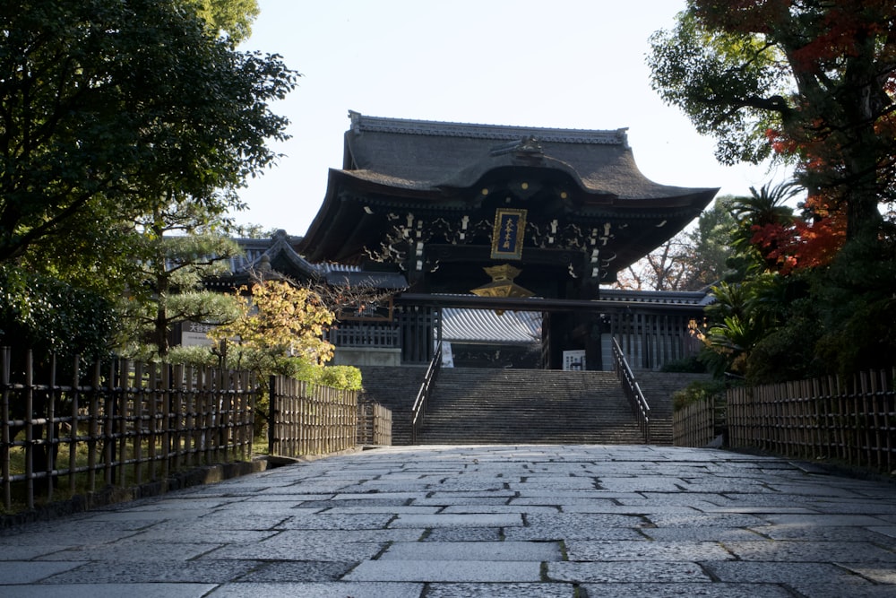 a stone walkway leading to a pagoda in a park