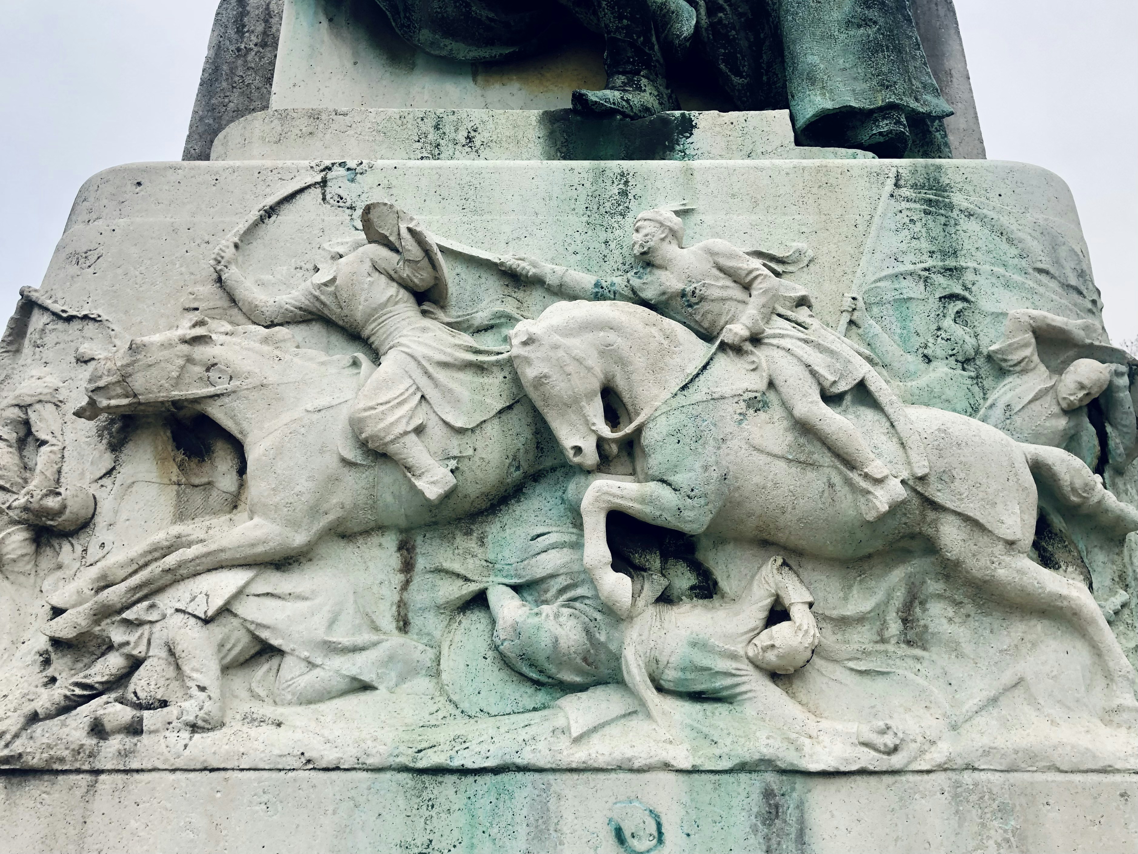 a statue of a man riding a horse next to a statue of a man on
