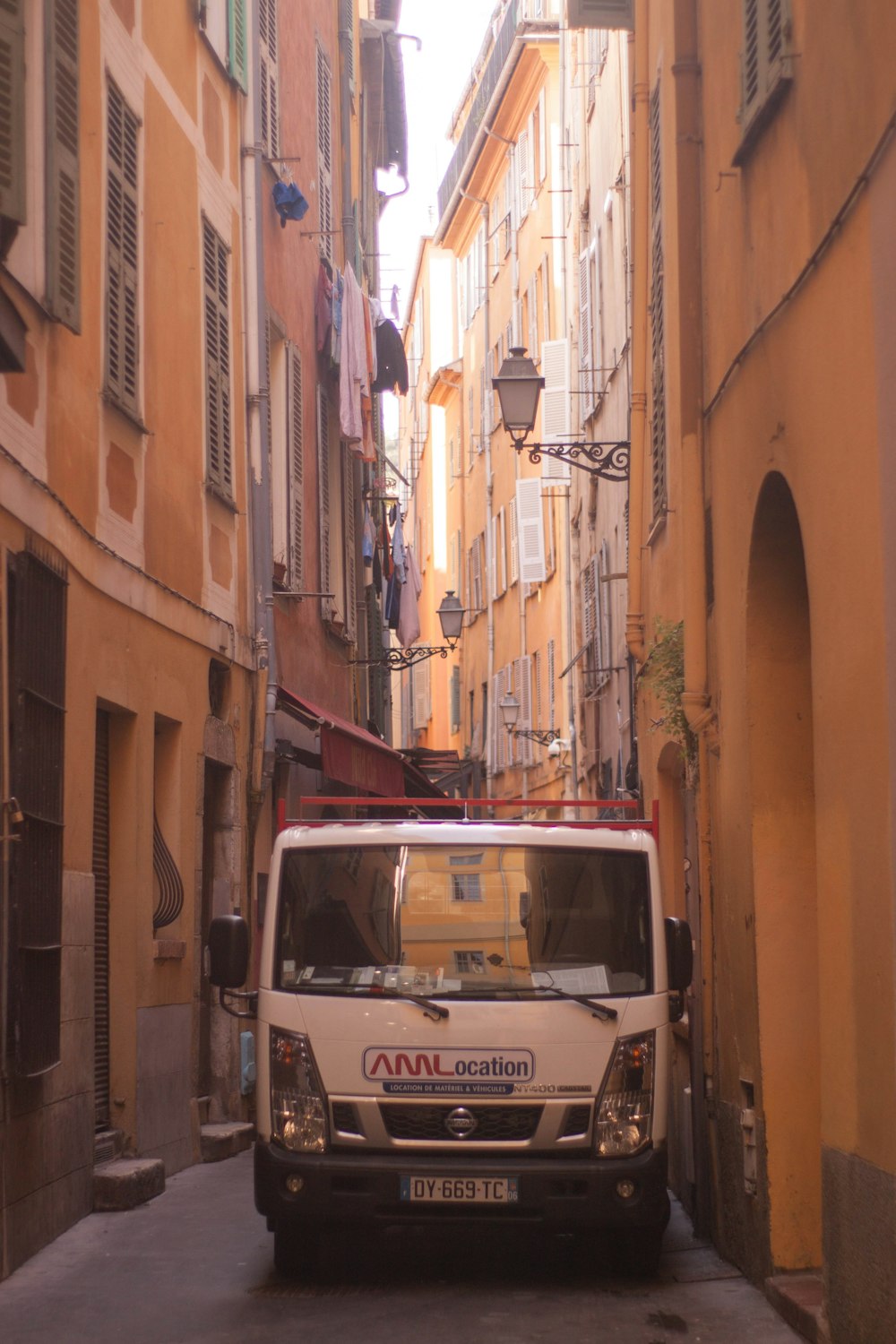 a van is parked on the side of a narrow street