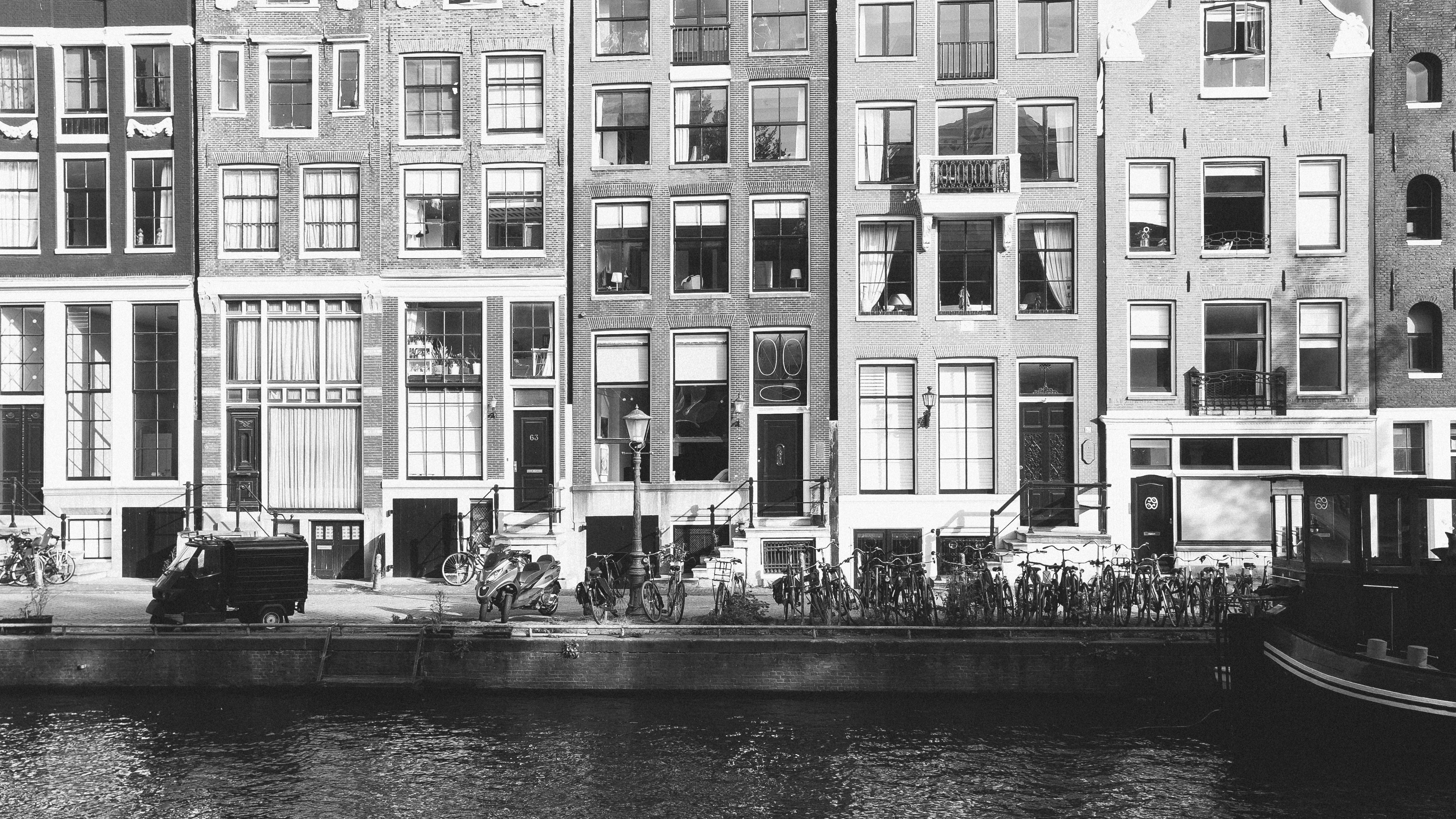 Hollanda'daki konaklama seçeneklerini temsil eden, Amsterdam'ın ikonik kanal evleri ve modern bir kiralık daire iç mekanı.