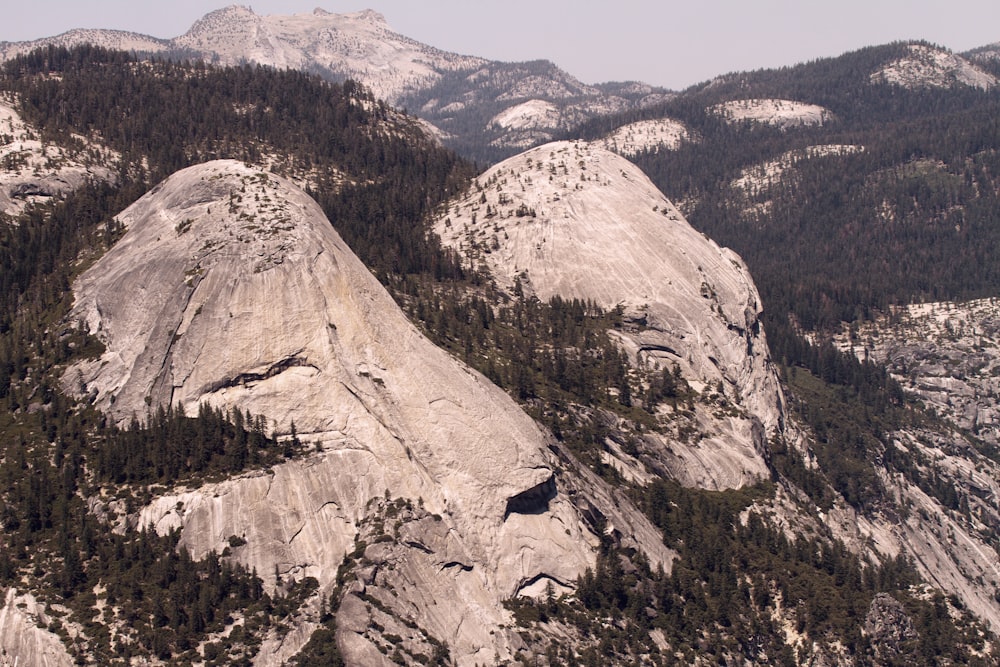 a view of a mountain range with trees and mountains in the background