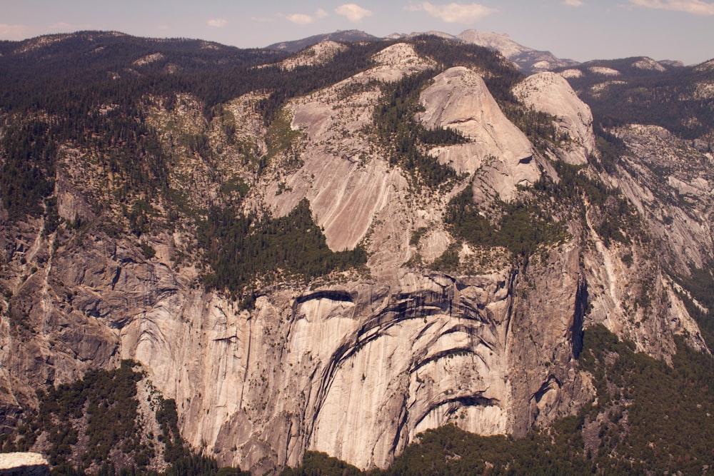 a view of a rocky mountain with trees on the side