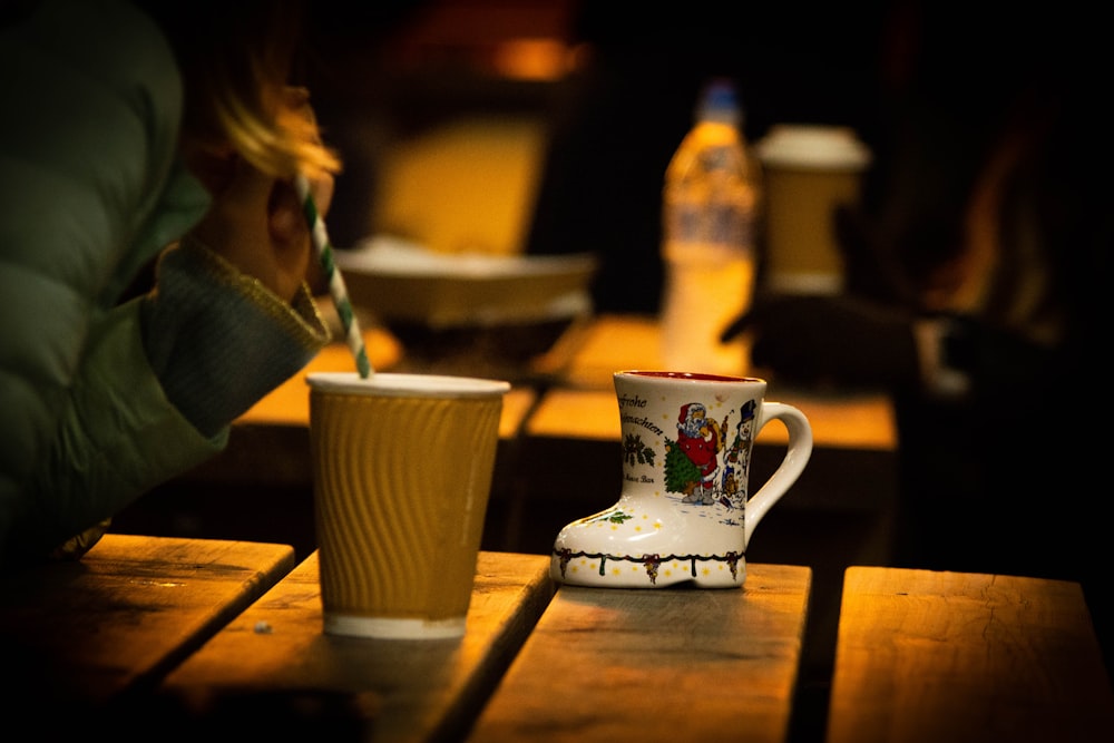 a cup of coffee sitting on top of a wooden table