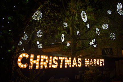 a christmas market sign lit up at night