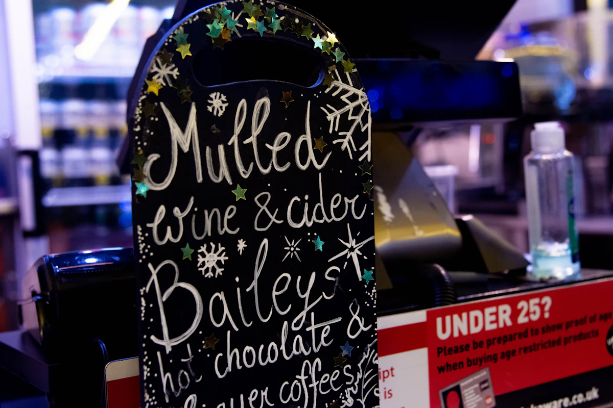 Chalkboard sign at a market stall listing mulled wine, cider and hot chocolate