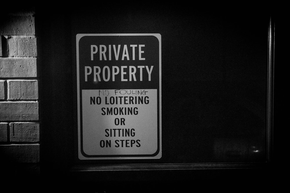 a black and white photo of a private property sign