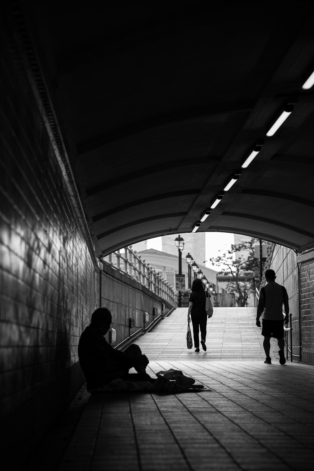 a person sitting on the ground in a tunnel