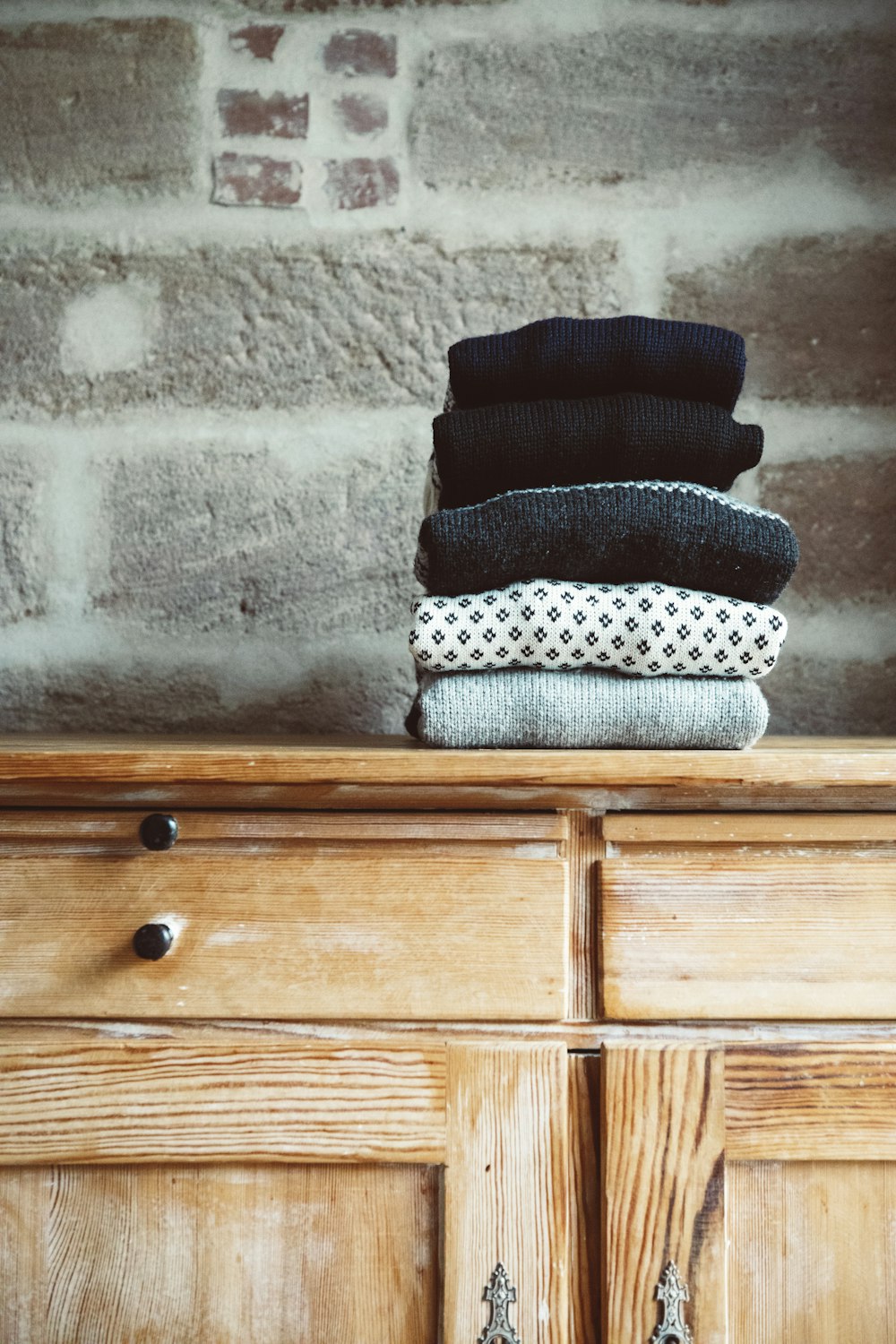 a stack of socks sitting on top of a wooden dresser