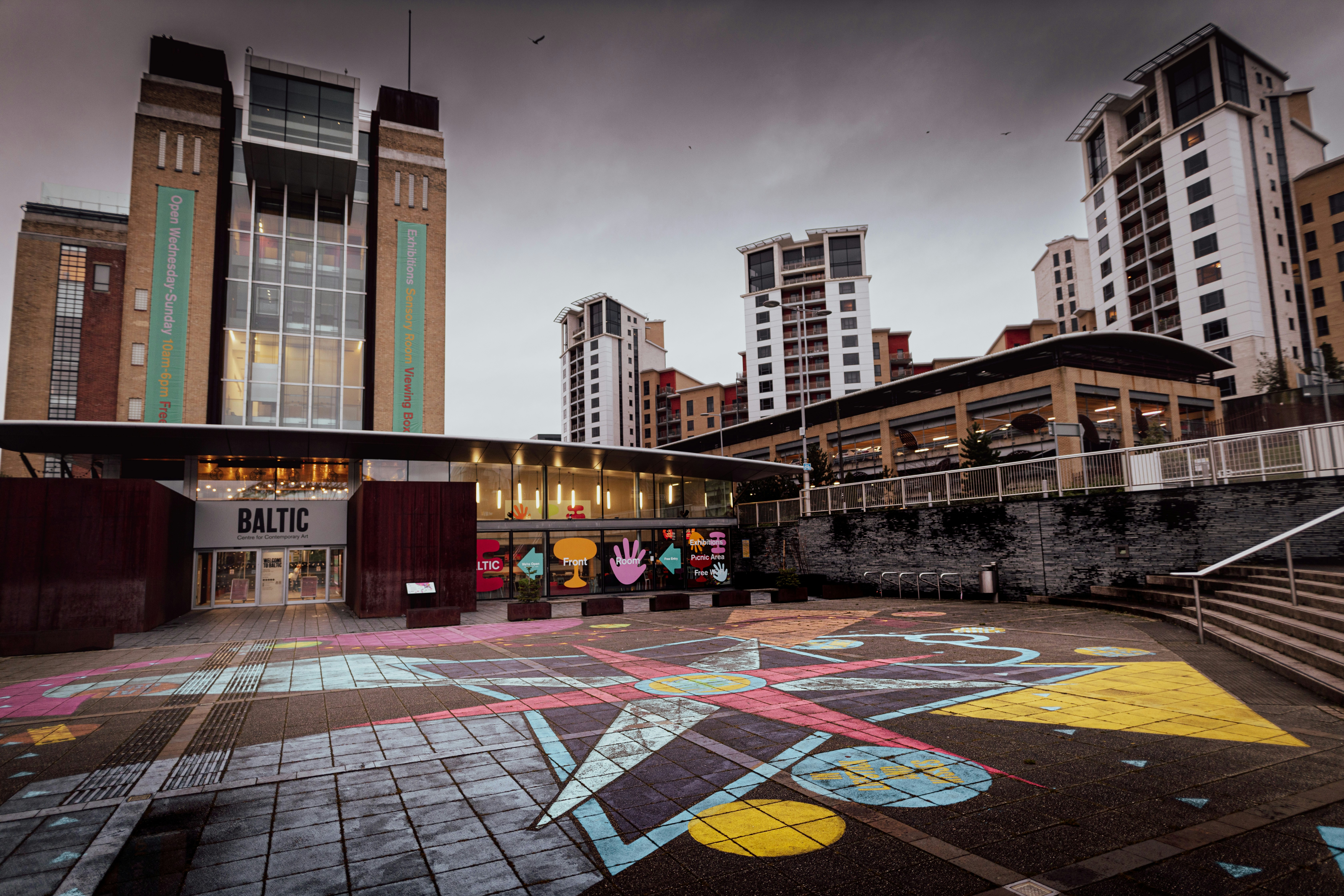 a building with a lot of windows and a lot of graffiti on the ground