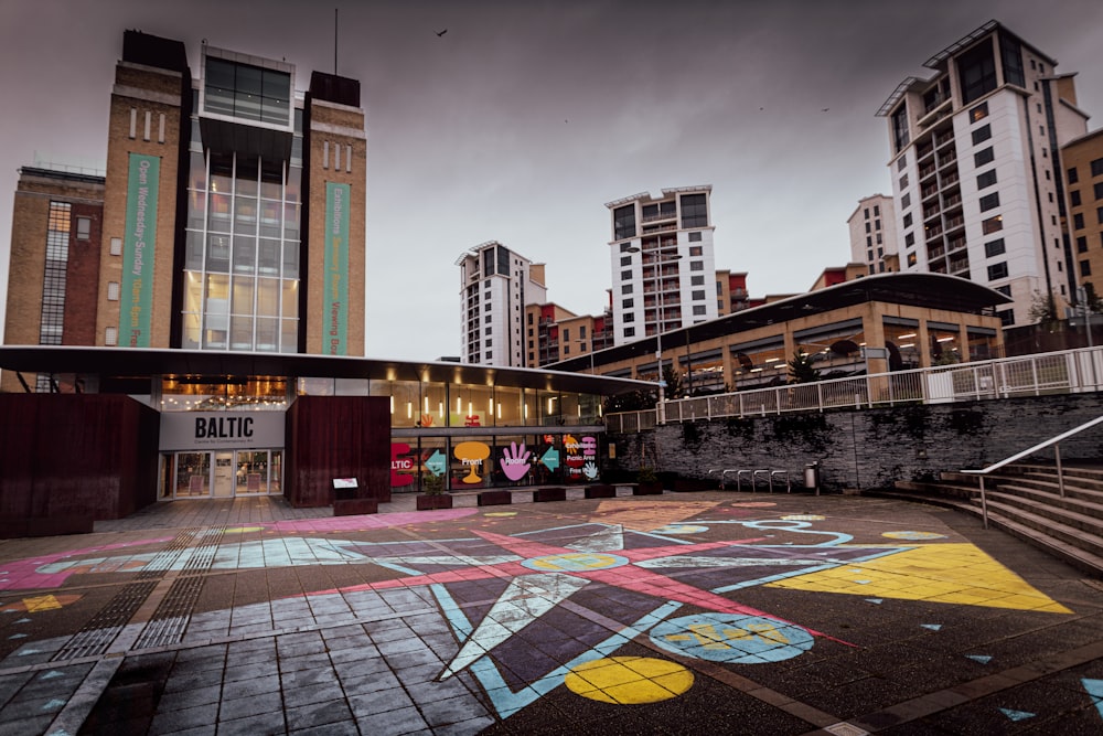 a building with a lot of windows and a lot of graffiti on the ground