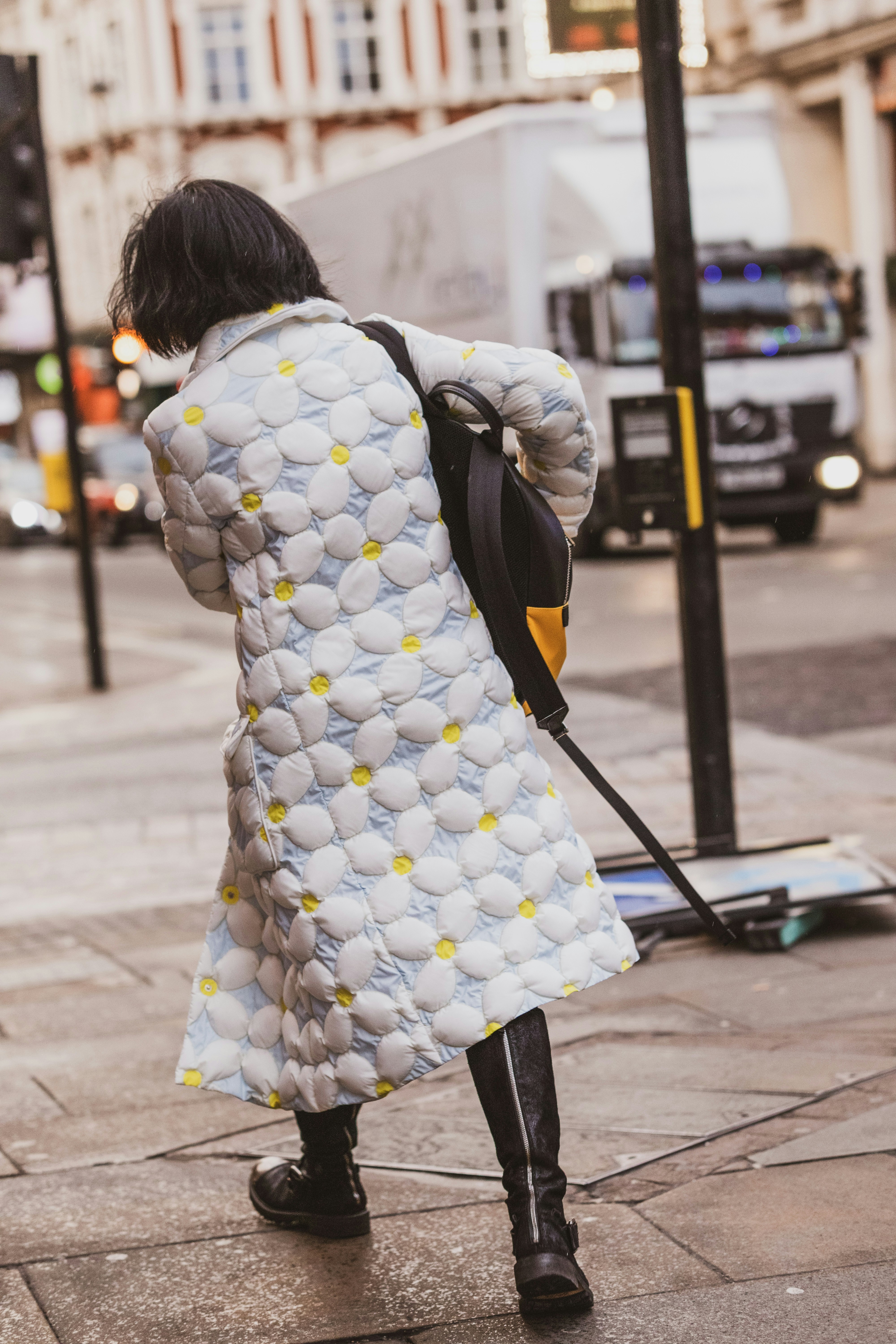 A woman in a white coat is walking down the street photo – Free London ...