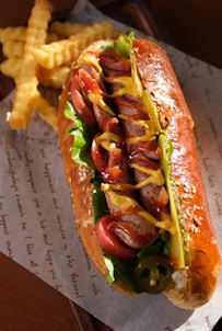 a hot dog on a bun with ketchup, mustard, and relish