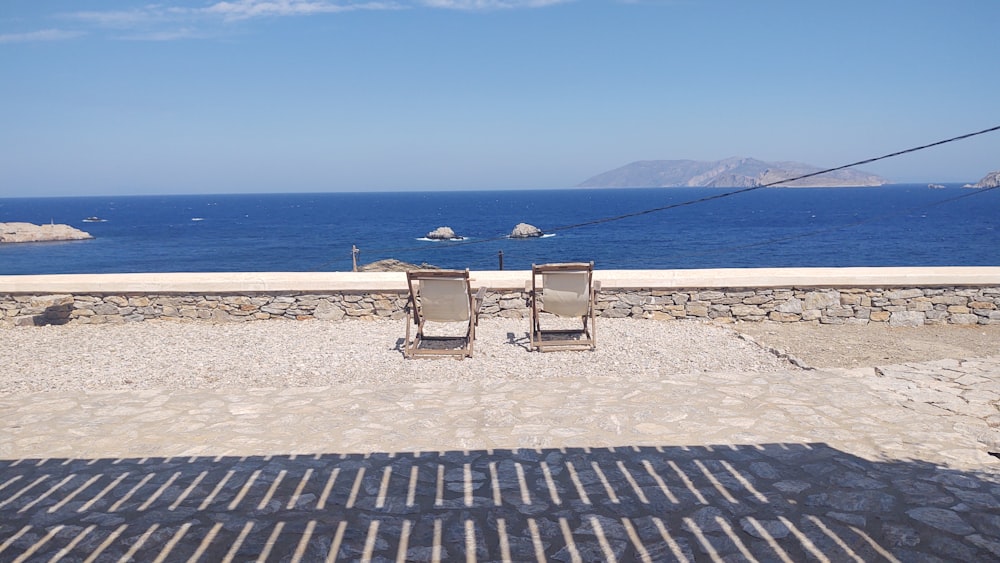 a couple of chairs sitting on top of a stone walkway