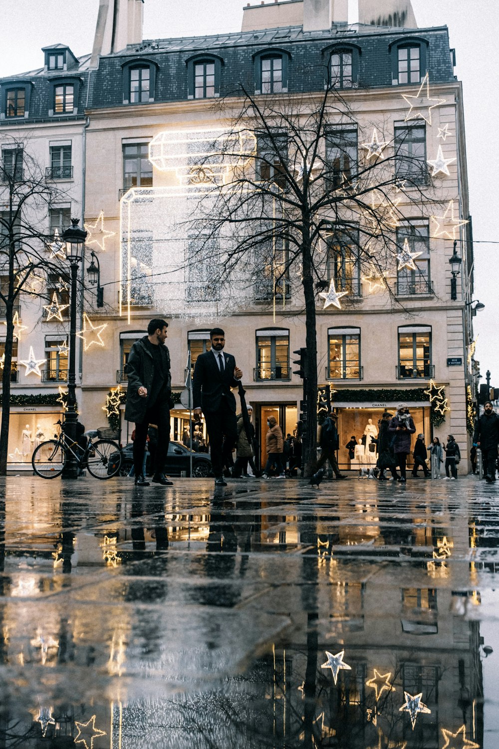 a group of people walking down a street next to a tall building