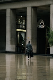 a man walking through a lobby with a suitcase