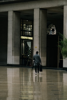 a man walking through a lobby with a suitcase