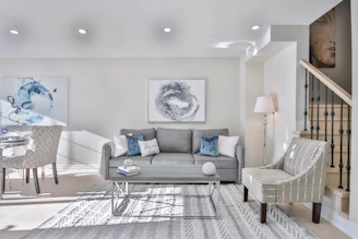a living room filled with furniture and a staircase