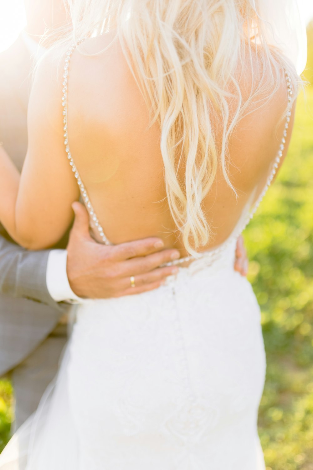 the back of a bride and groom's wedding dress