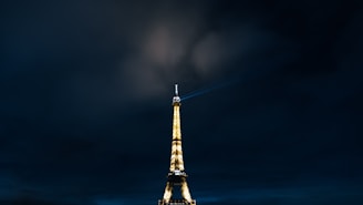 the eiffel tower is lit up at night
