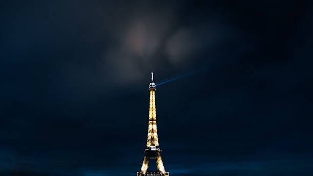the eiffel tower is lit up at night