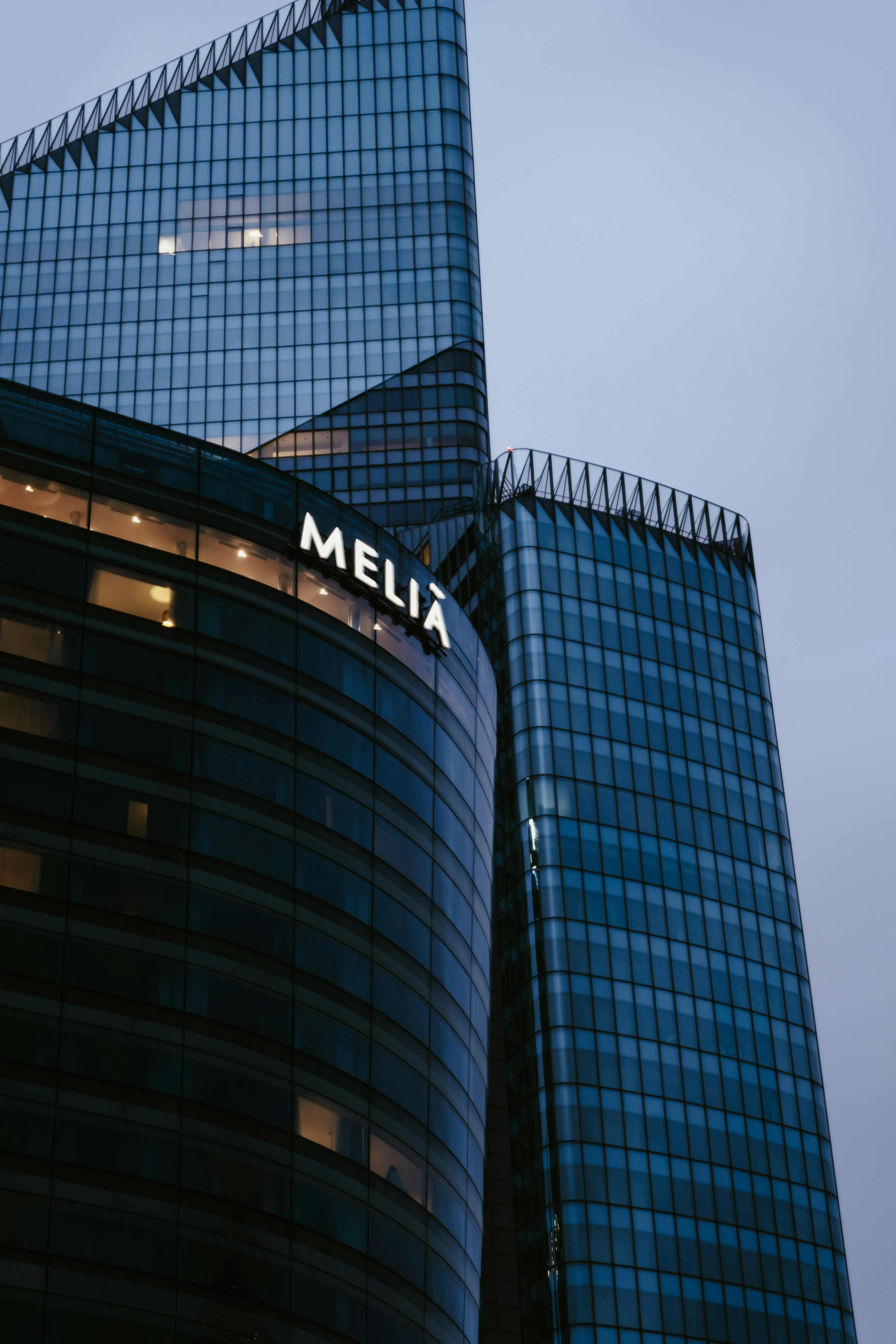 a tall glass building with the word melia on it